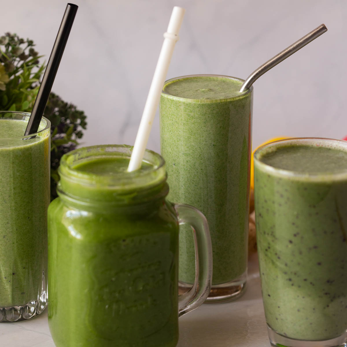 Six green smoothie glasses on the table.
