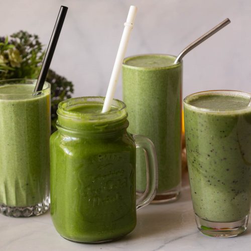 Six green smoothies on the table.