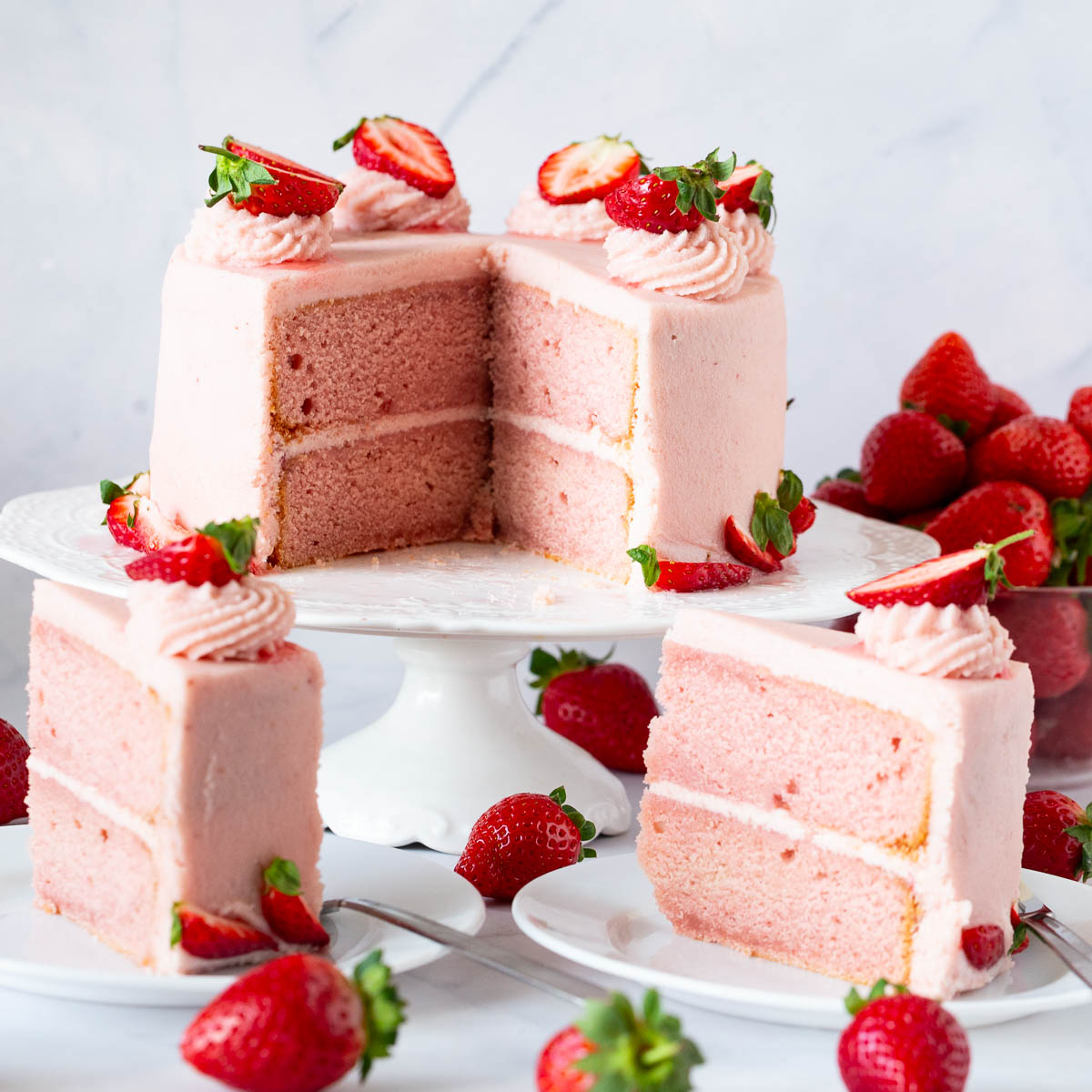 A sliced strawberry cake on the cake stand.