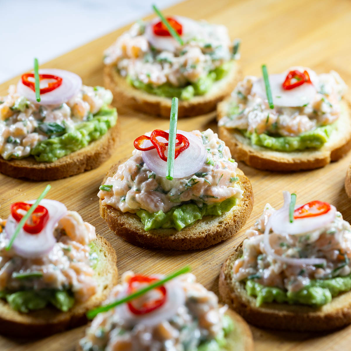 Brioche canapes with salmon tartarte on the table,