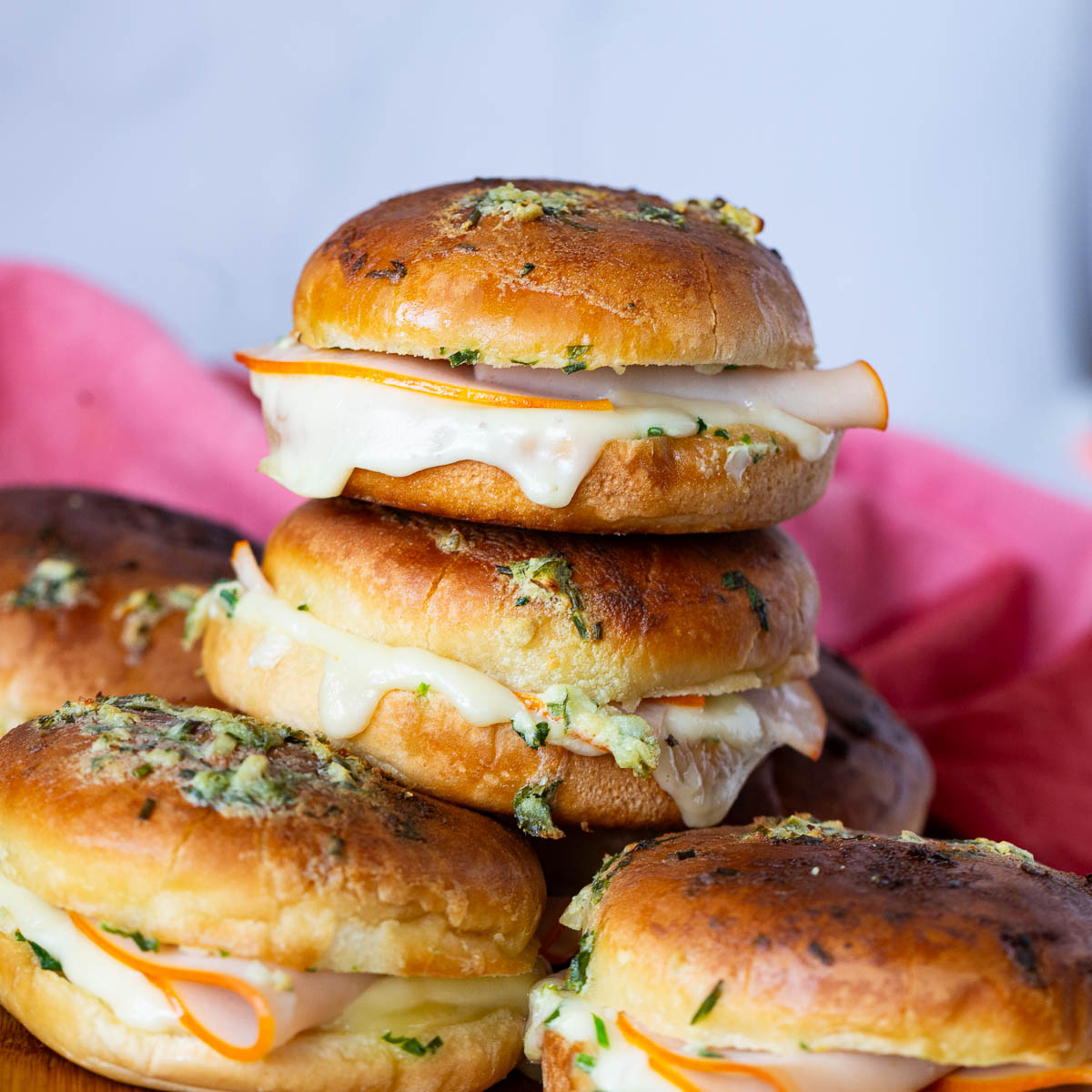 A stack of ham and cheese sliders.