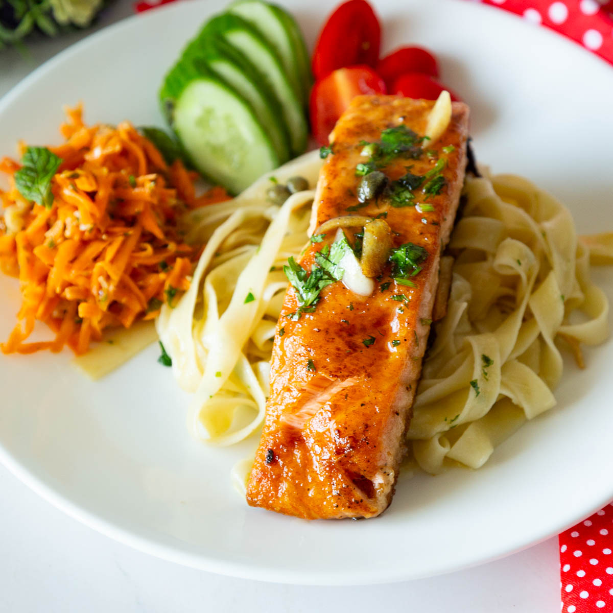 A plate with noodles and salmon.