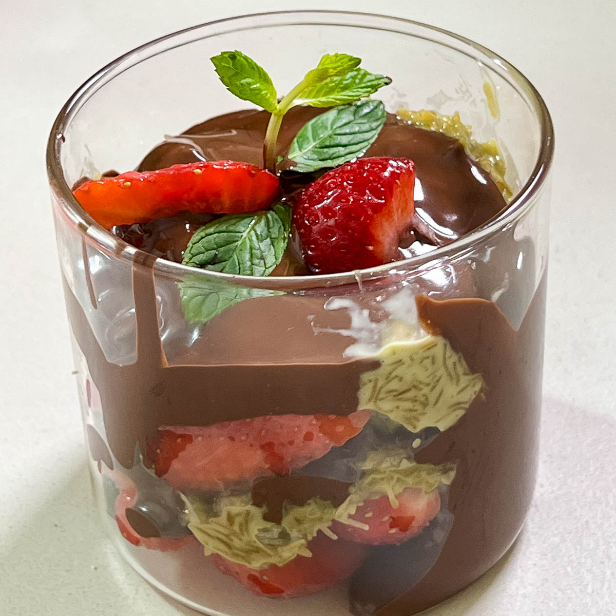 A glass cup with dubai chocolate dessert.