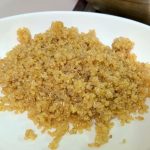 A white plate with fluffy quinoa.