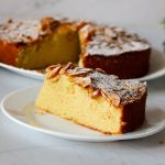 A sliced almond cake on the table.