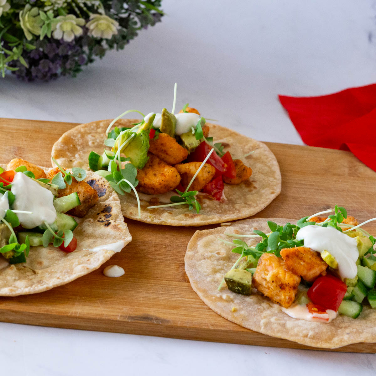 Salmon tacos with veggies on the table.