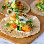 A wooden board with salmon tacos.