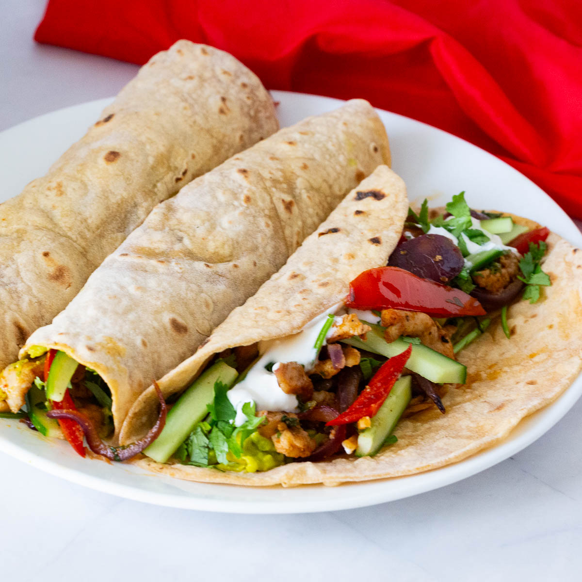 A white plate with chicken fajitas.