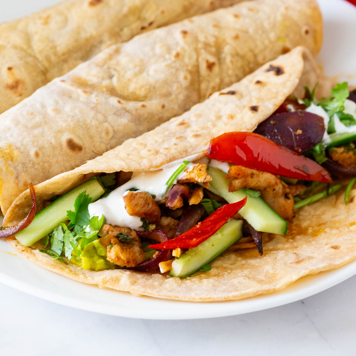 Tortillas with chicken fajitas on the table.
