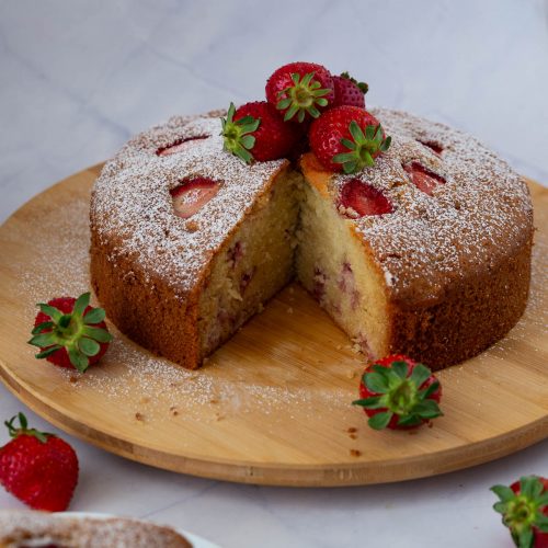 A sliced strawberry on the cake board.