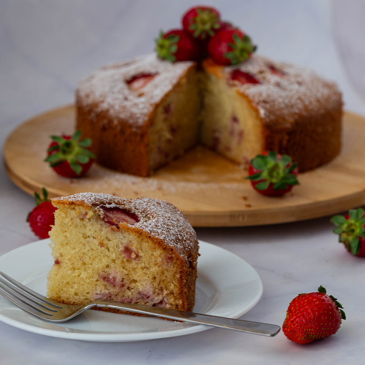 A sliced strawberry cake on the table.