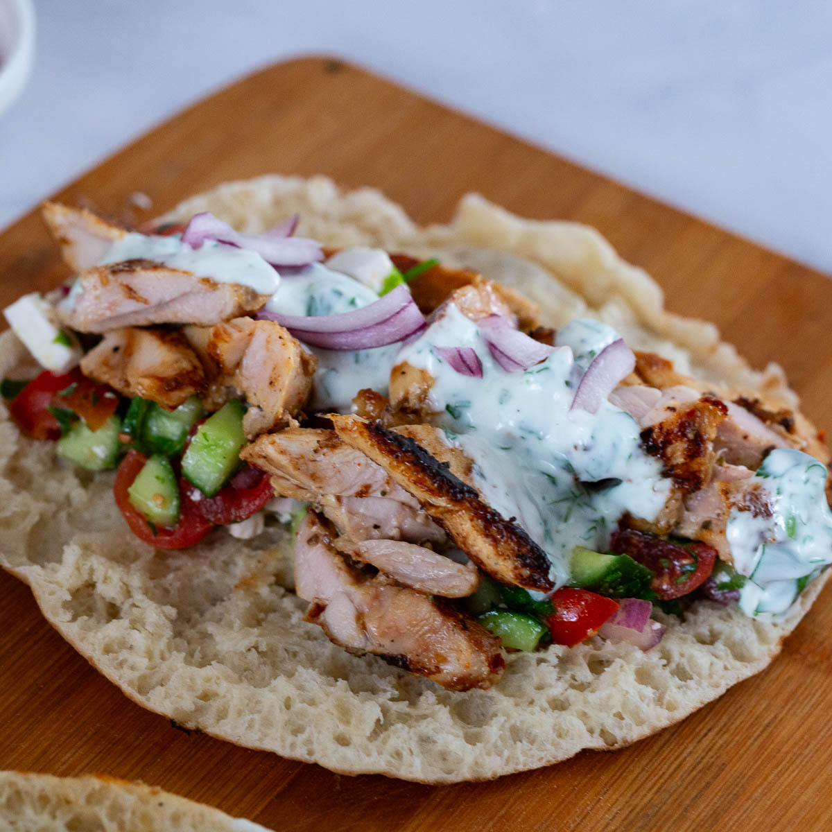 A pita stacked with gyros and salad.