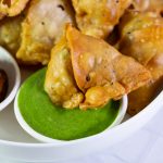 Samosa with green chutney on the table