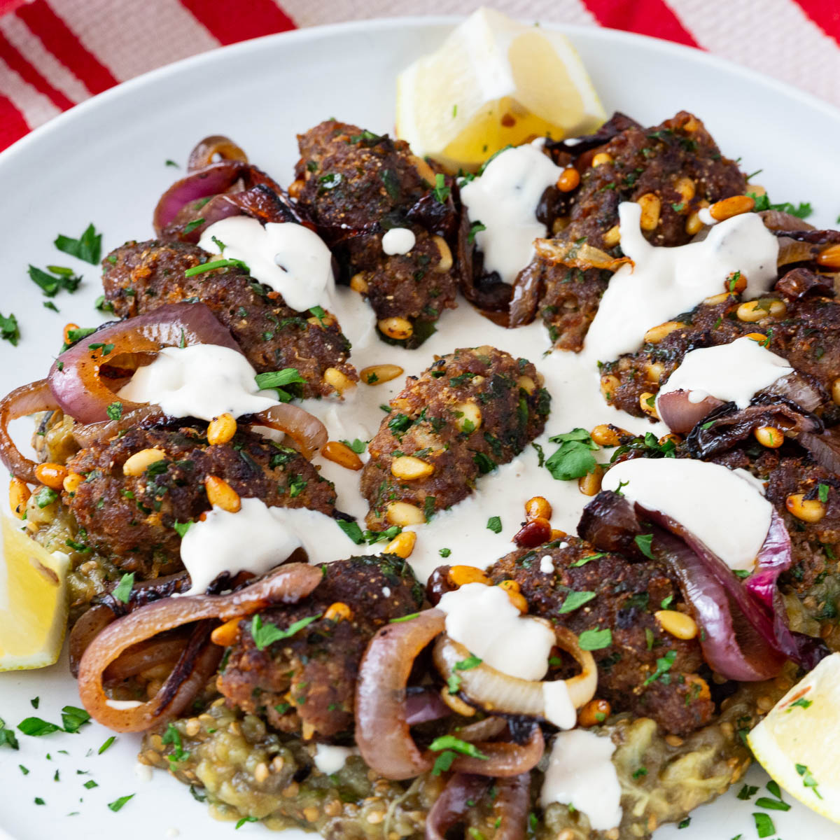A platter with beef kebabs and eggplant puree.