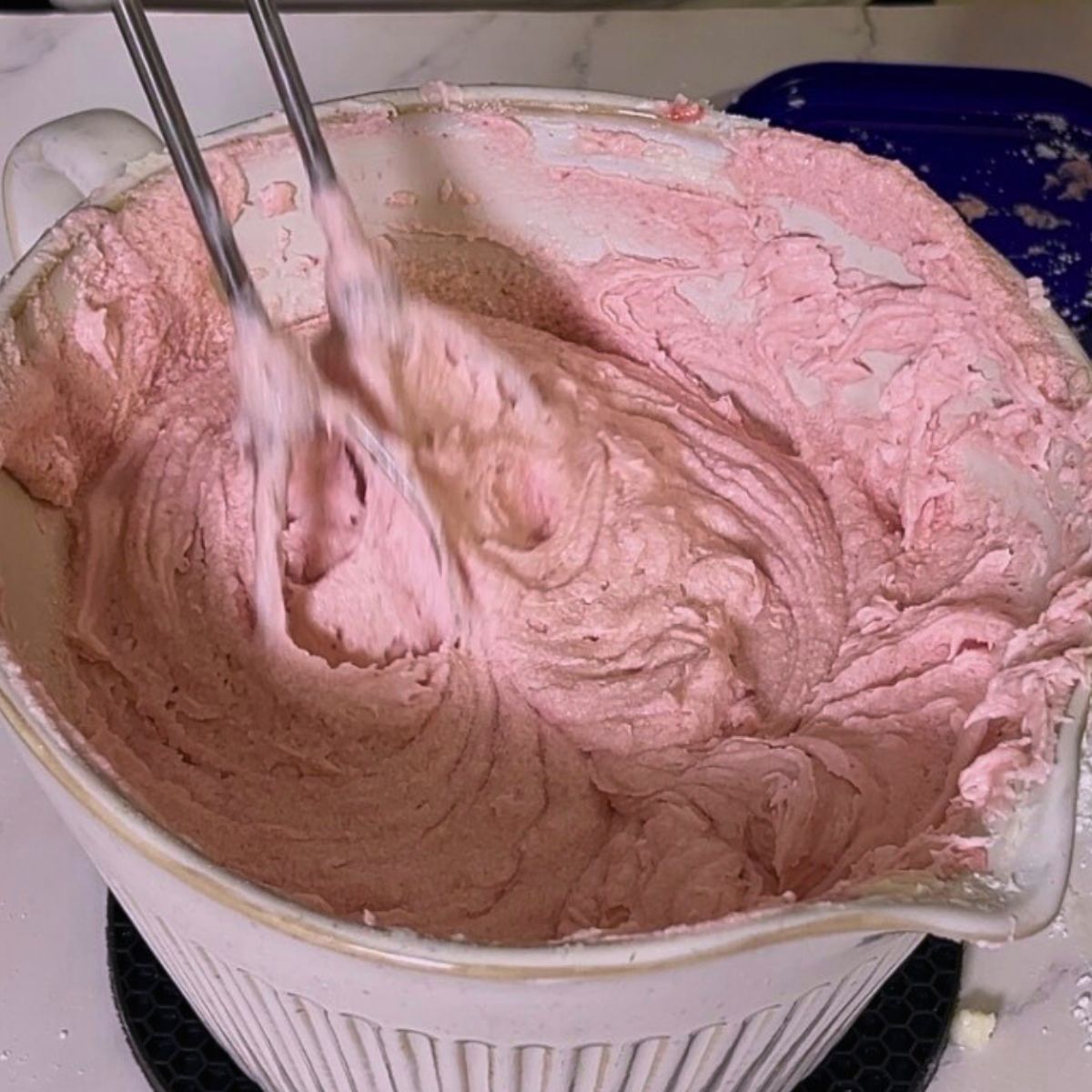 A bowl with frosting on the table.