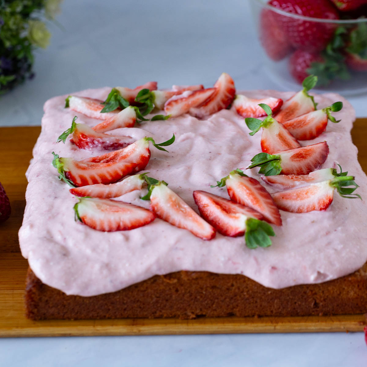 A square cake with cream cheese froting.