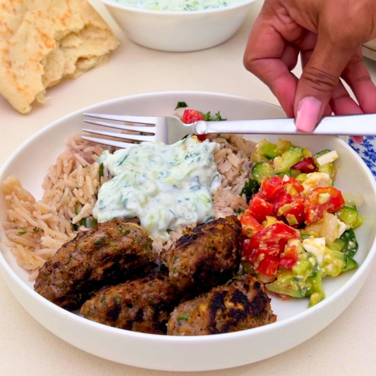A white plate with Greek kofta kebabs.
