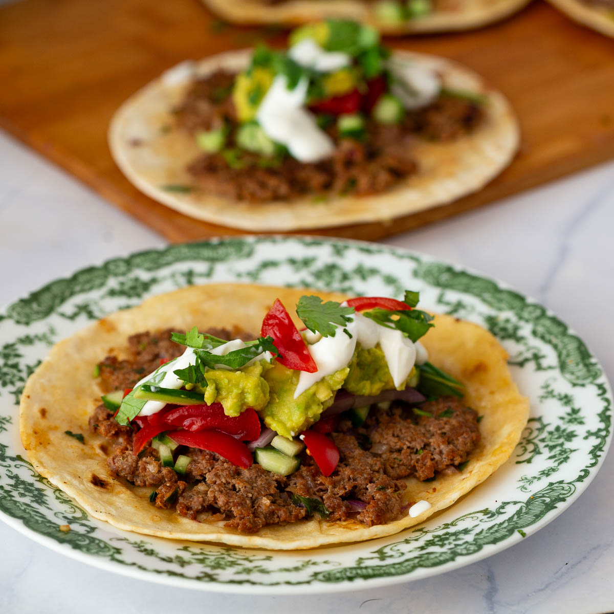 Mexican-style smashed tacos with avocado and tomato
