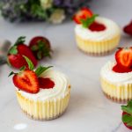 Mini cheesecakes with strawberry on the table.