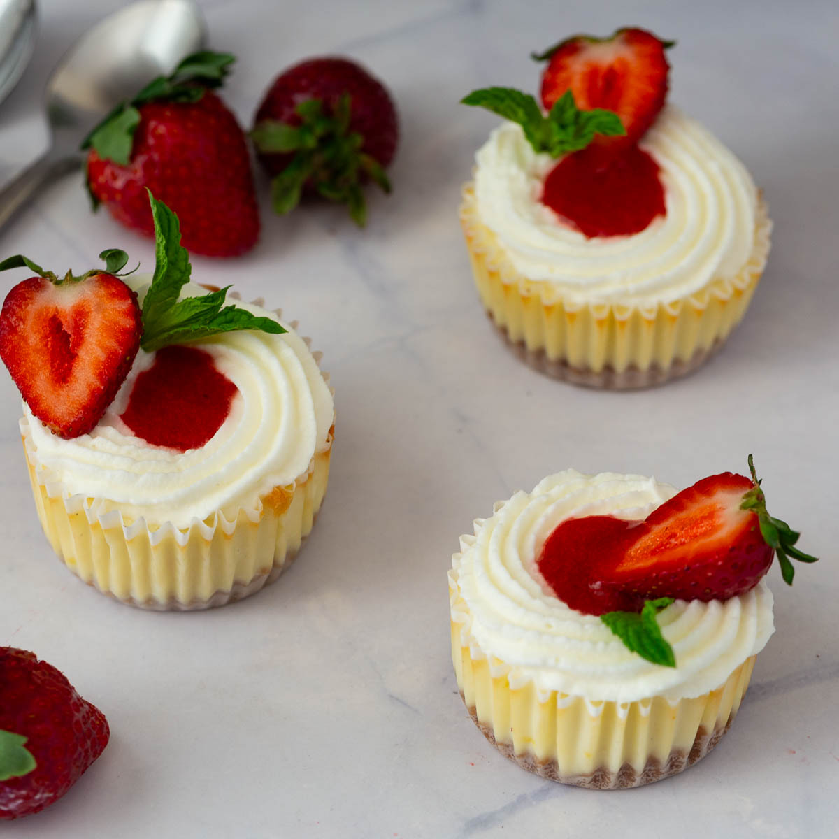 Strawberry baked mini cheesecakes on the table.