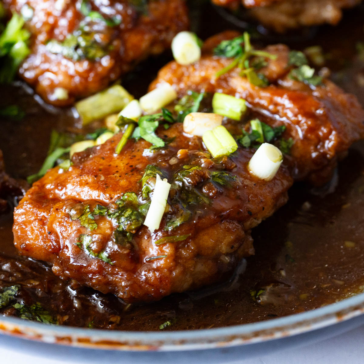 A saute pan with honey garlic chicken.