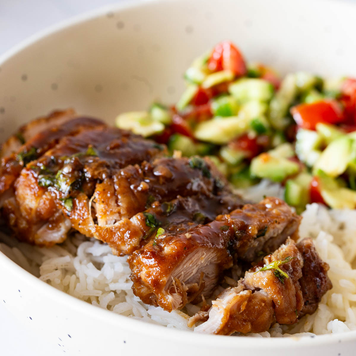 A plate with rice salad and honey chicken.
