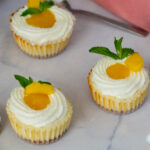 Mini cheesecakes on the table with mango puree.
