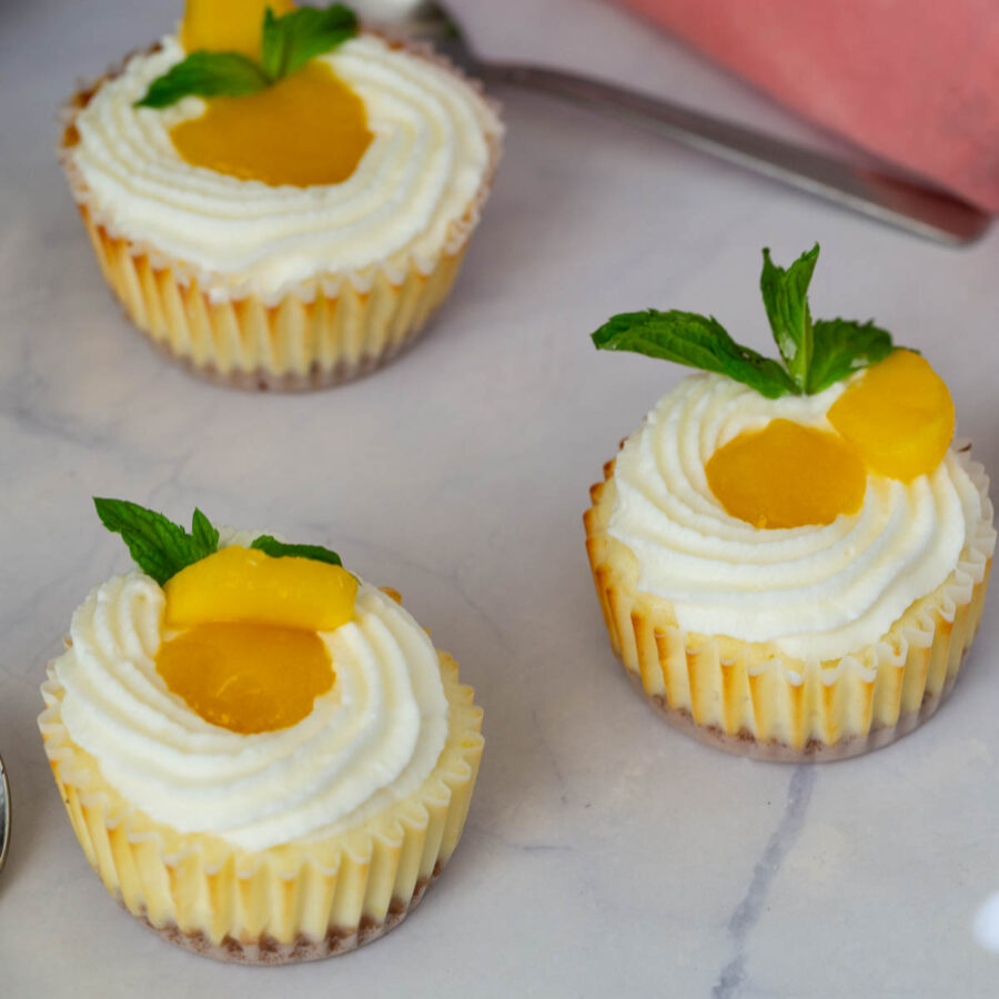 Mini cheesecakes on the table with mango puree.