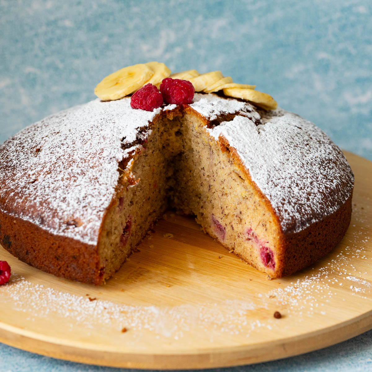 A sliced banana raspberry cake on the table