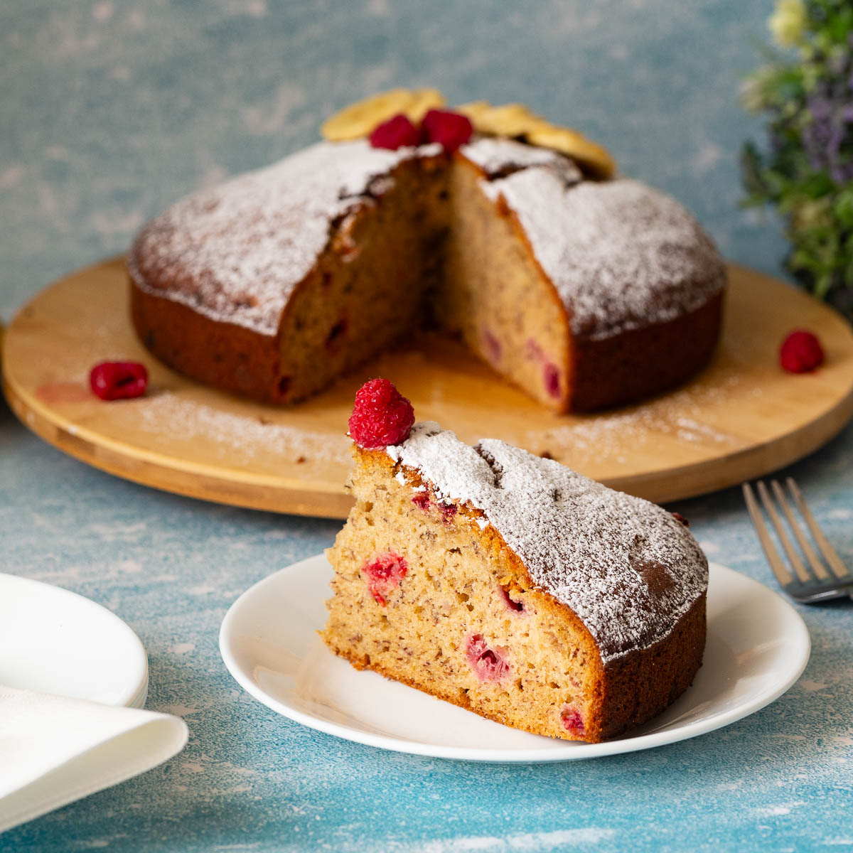 A slice of banana raspberry cake on the table.