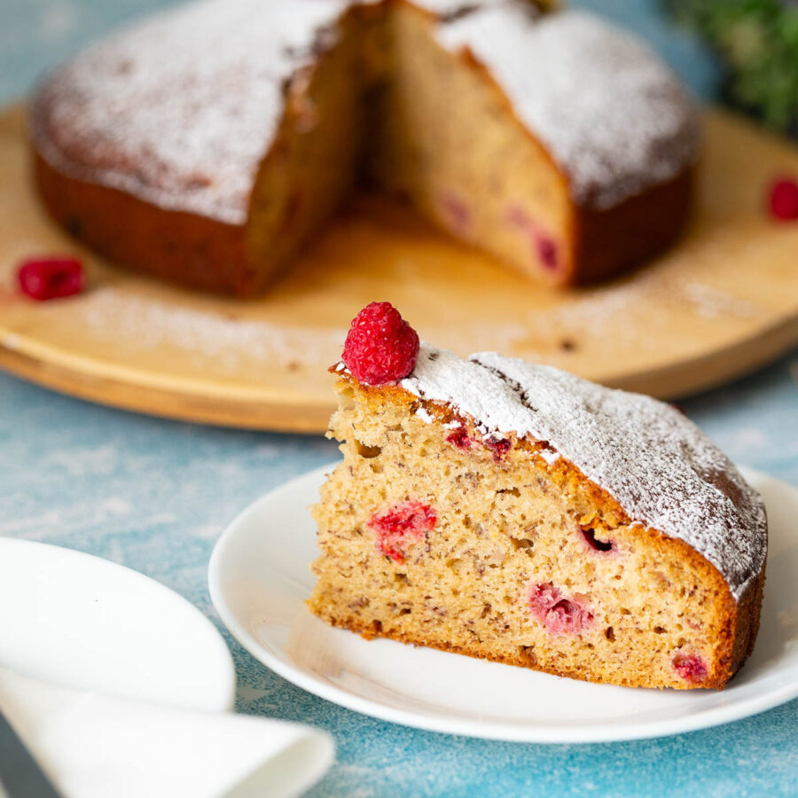 A slice of banana-raspberry cake on the plate.