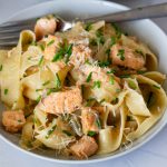 A plate with pasta in brown butter sauce with salmon.