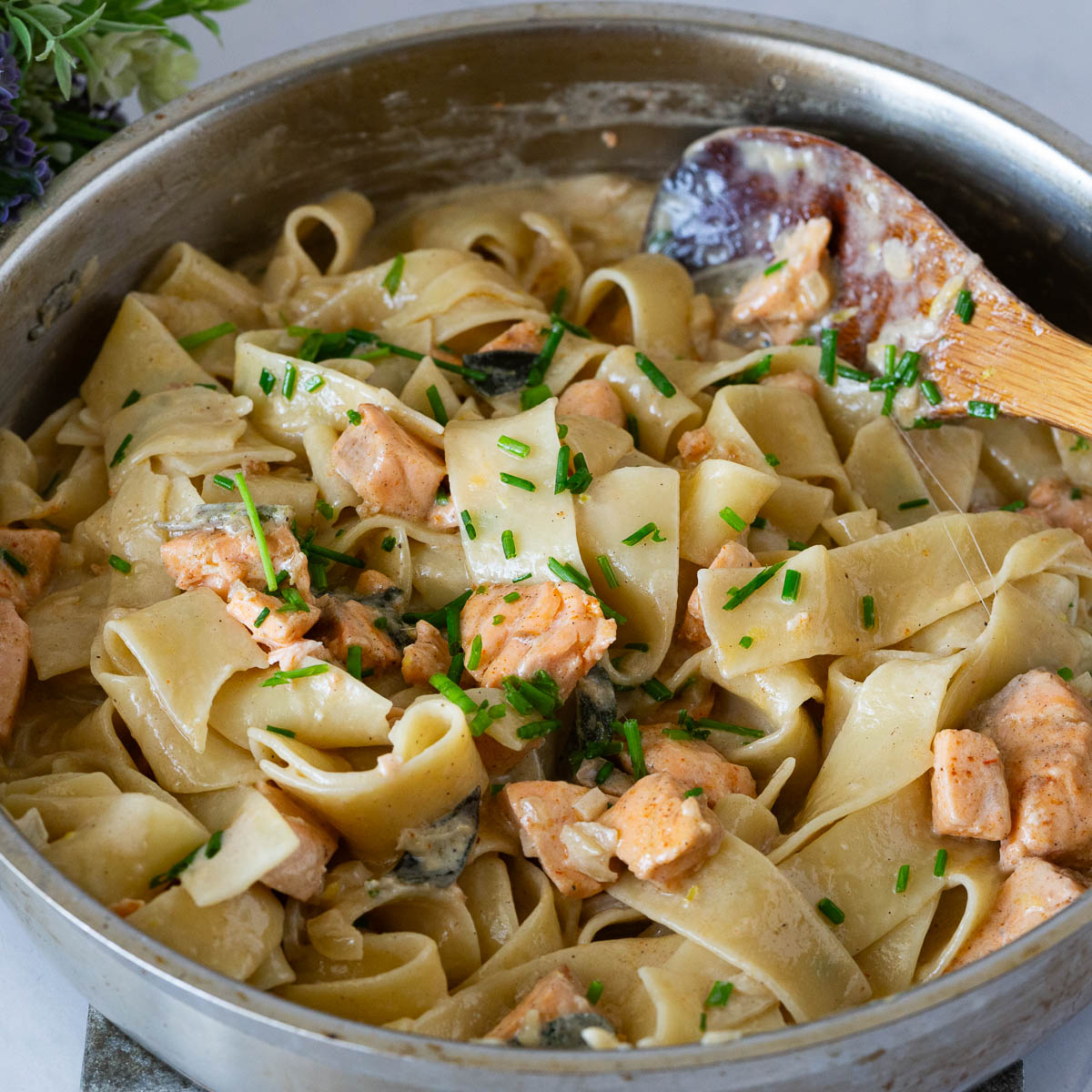 A skillet with salmon and pasta.