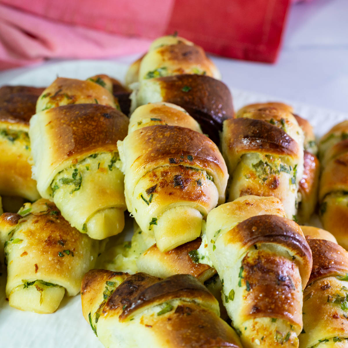 Bread rolls with garlic, parmesan, and scallions on the table.