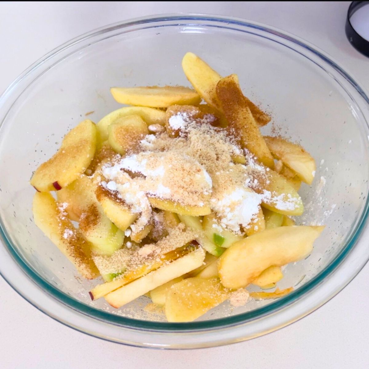A bowl with apple slices and cinnamon sugar.