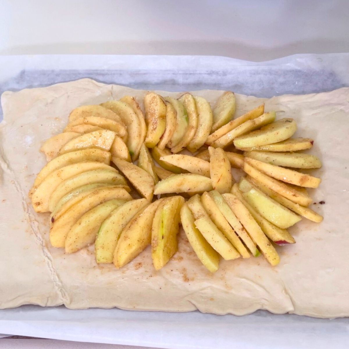 Apple sliced with cinnamon sugar on puff pastry.