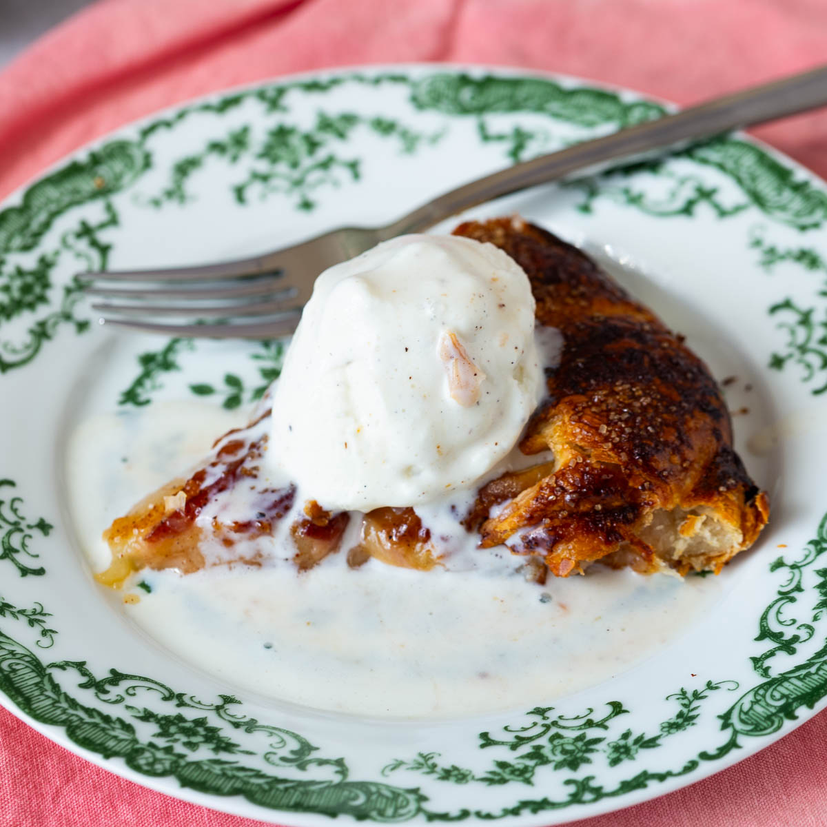 A slice of peach galette with ice cream on the plate.