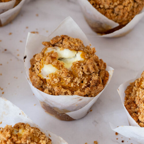 Pumpkin muffins with cream cheese on the table.