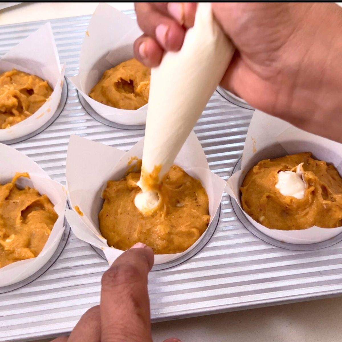Pumpkin muffins filled with cream cheese.
