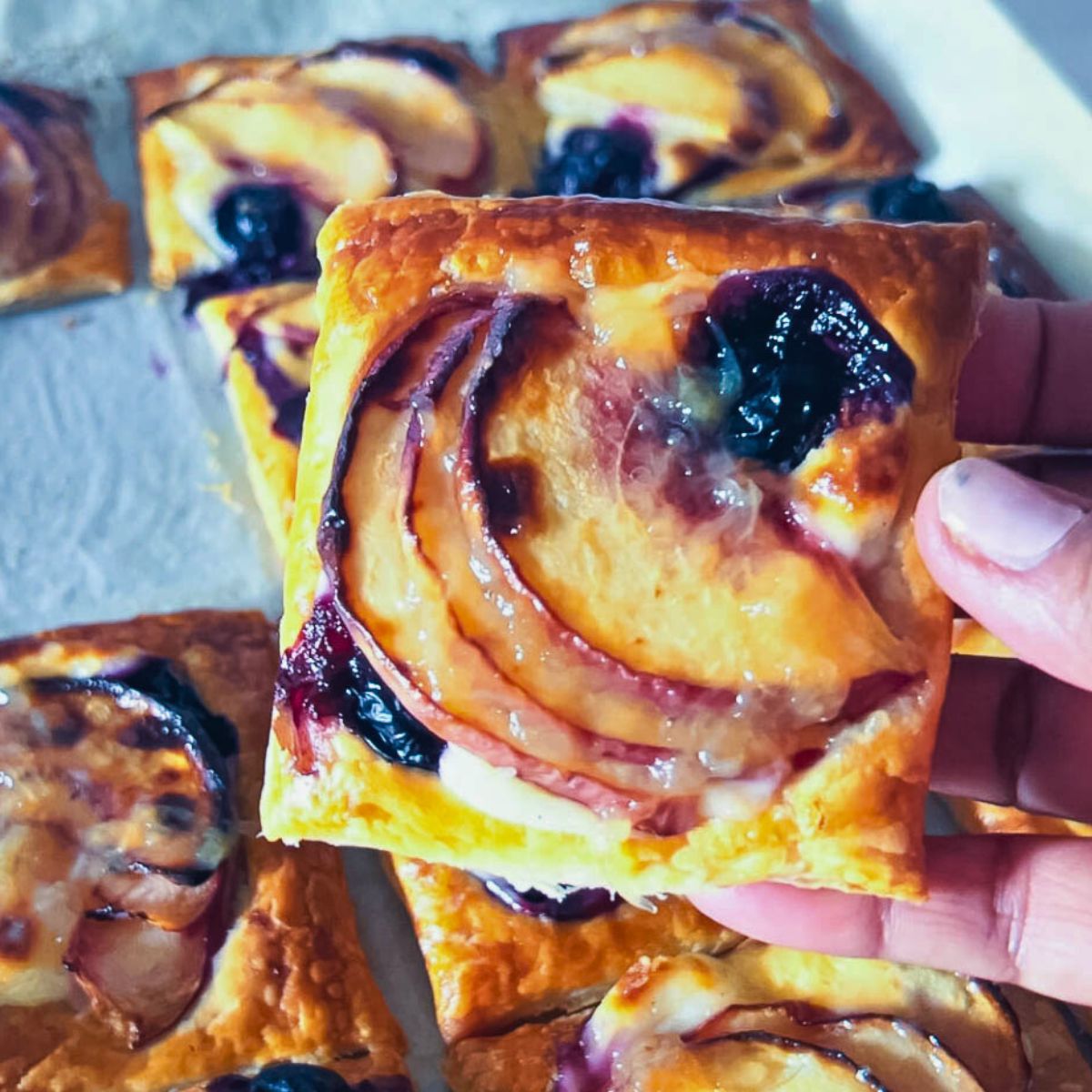 Blueberry peach puff pastry on a baking tray.