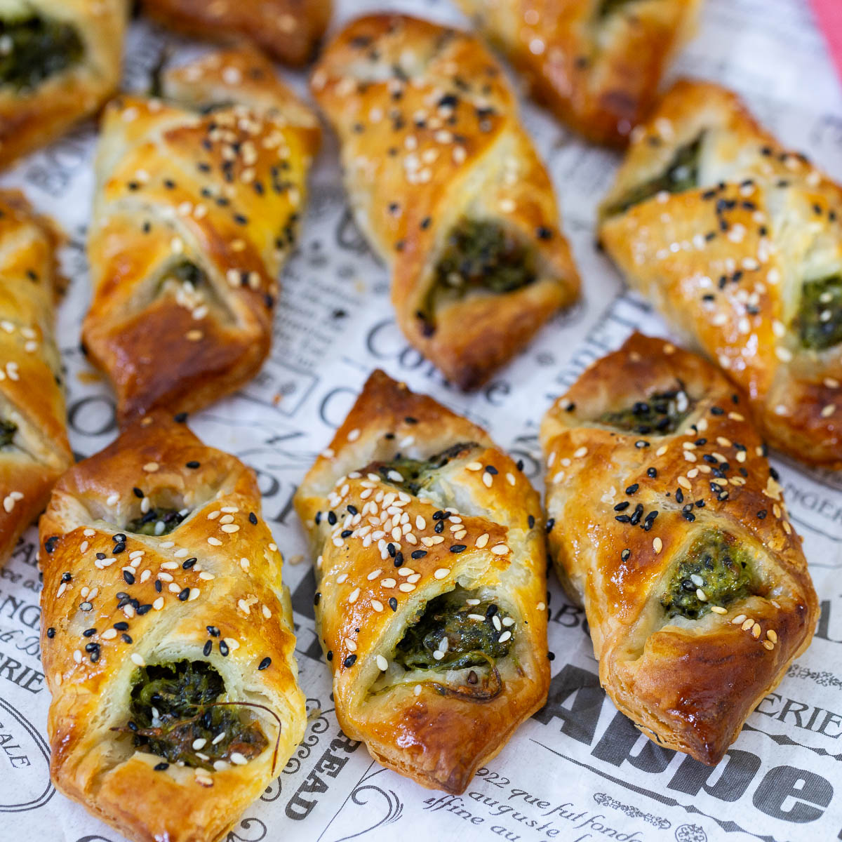Spinach cheese puff pastry appetizers on the paper.
