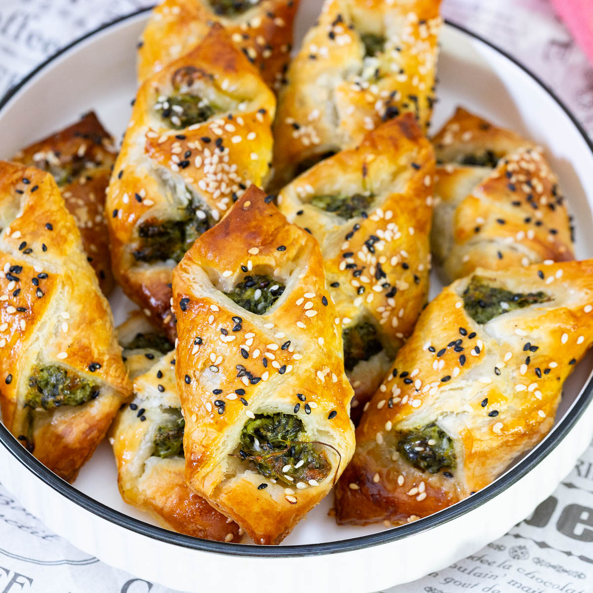 A paper with puff pastry appetizers.