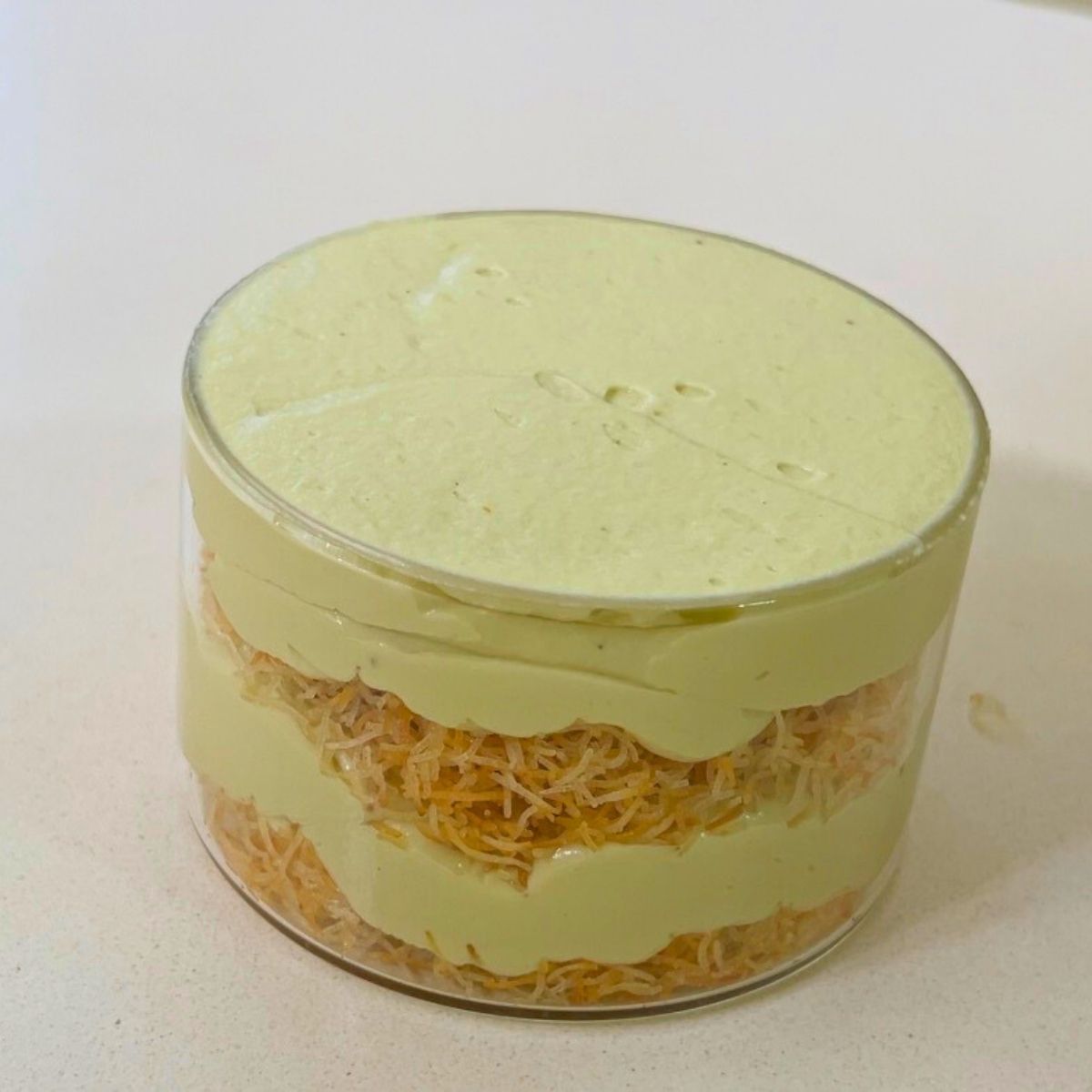 Layering the trifle with kataif and pistachio cream cheese.