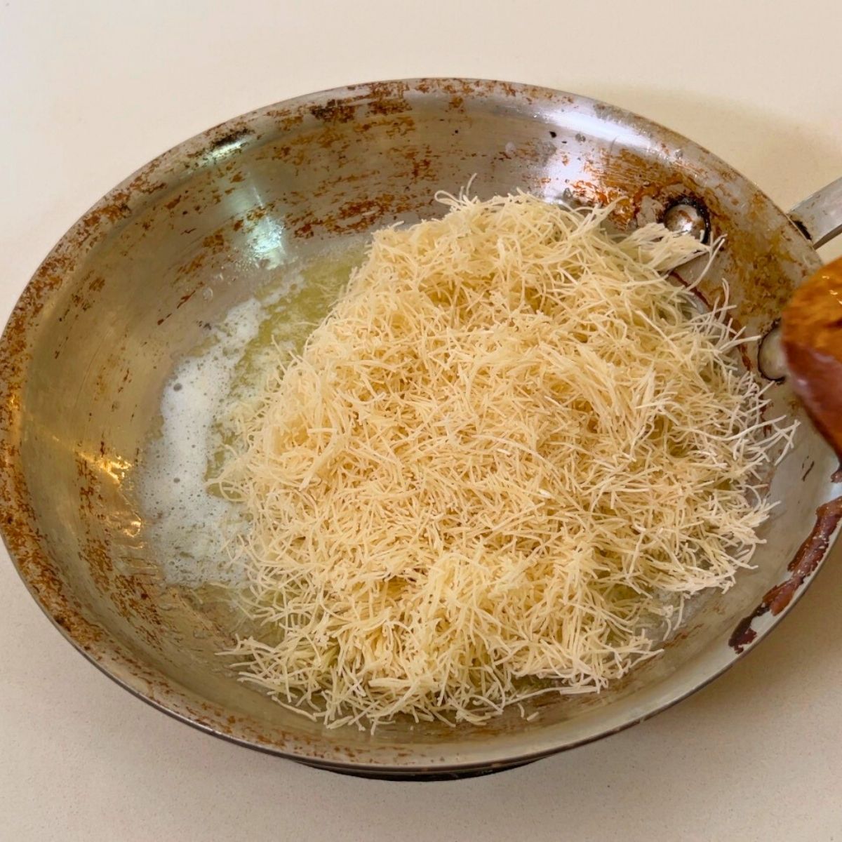 A frying pan with kataif and butter for roasting.
