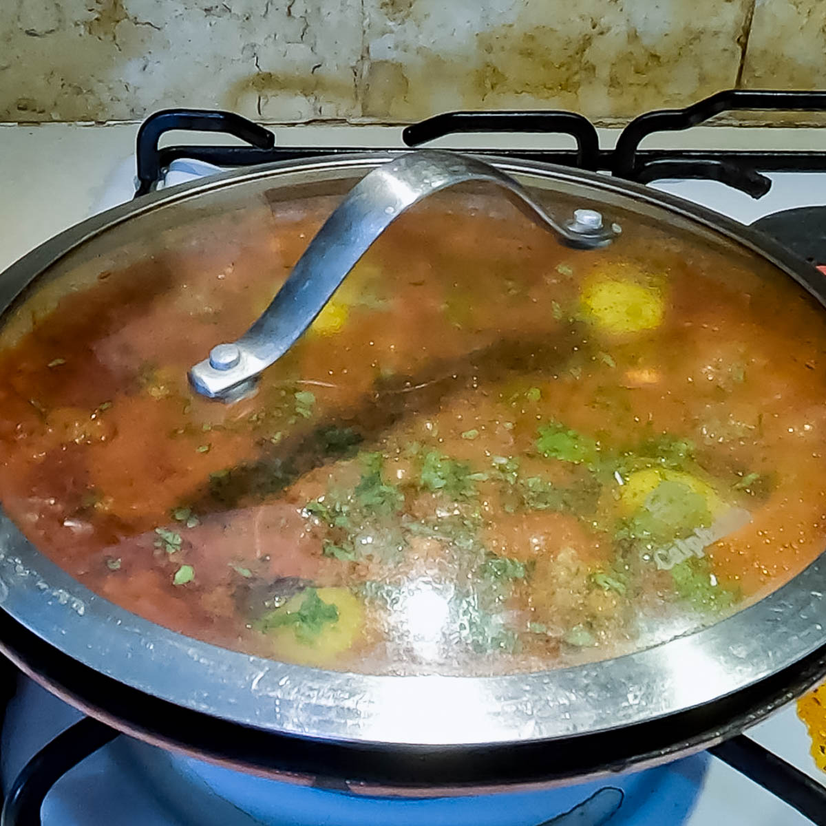 Finished Moroccan kefta tagine topped with poached eggs and parsley.