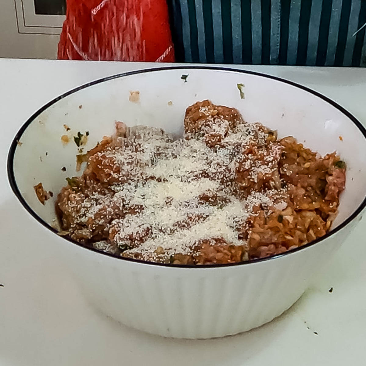 Mixing ground beef and lamb with onion, garlic, semolina, and spices in a bowl.