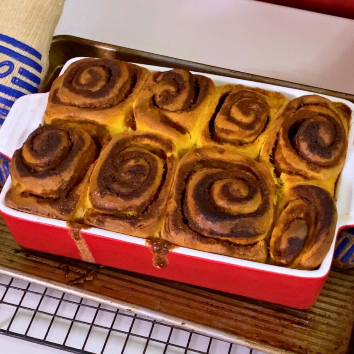 Fresh baked cinnamon rolls in a red baking dish.