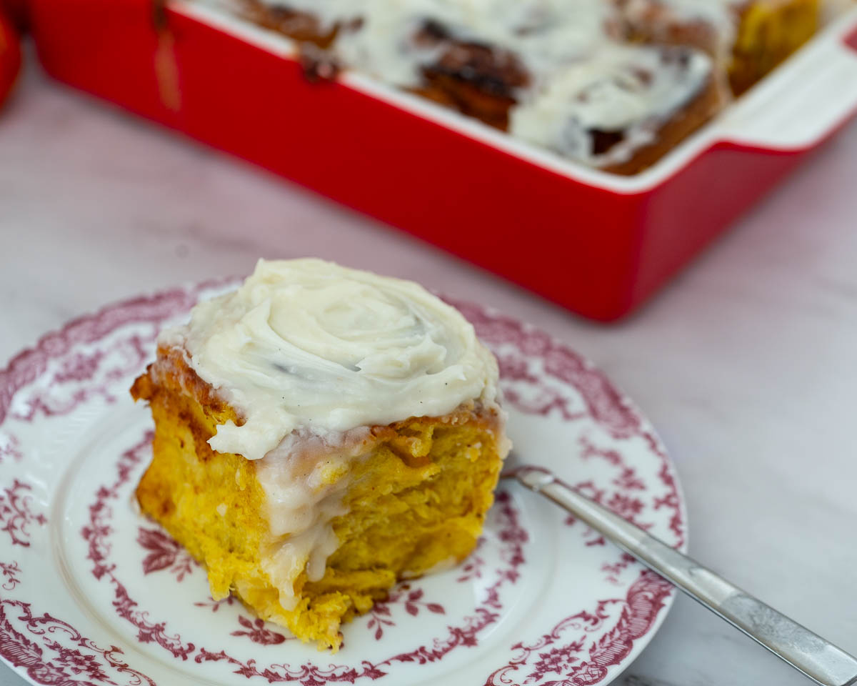Slice of pumpkin cinnamon rolls on a plate.
