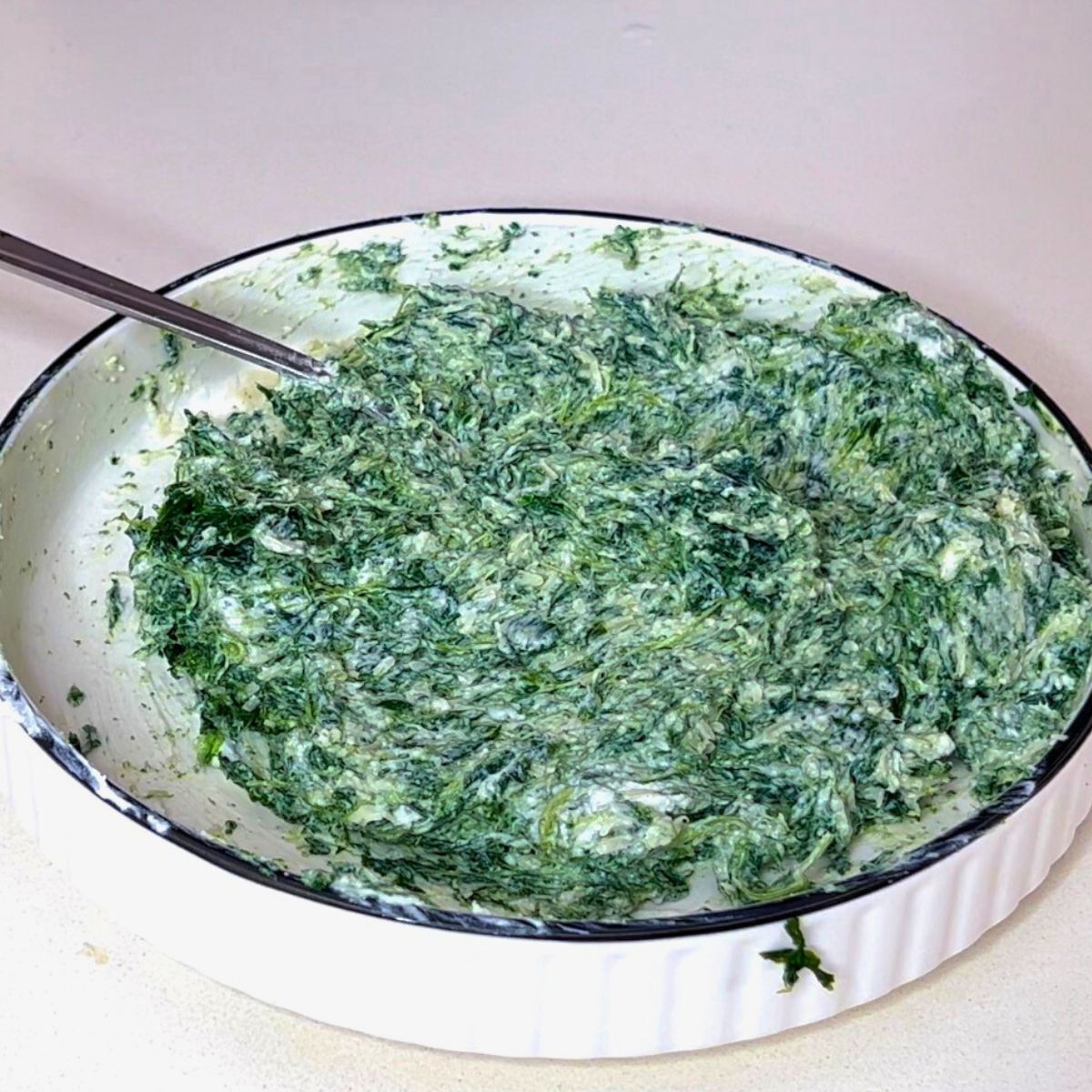 A bowl with spinach cream cheese with Puff pastry.