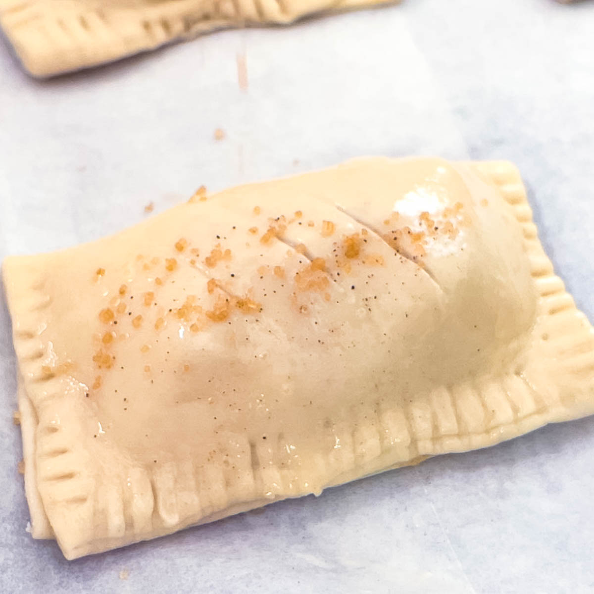 Egg washing a puff pastry turnover.
